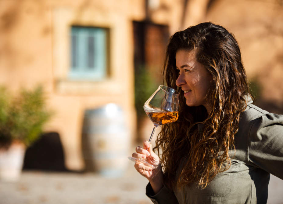 Femme dégustant un vin dans une cave de vignoble